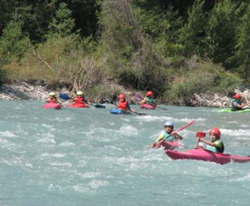 Dans cette photo dynamique, un groupe d'adolescents en kayak parcourt la rivière Durance avec une détermination audacieuse. Les visages souriants témoignent de l'esprit d'équipe et de l'excitation qui les animent alors qu'ils affrontent les rapides de cla
