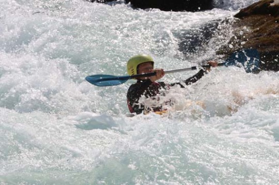 Dans cette photo captivante, un kayakiste expérimenté fait preuve d'une maîtrise exceptionnelle en naviguant avec adresse à travers un rapide agité. Son corps est en parfaite harmonie avec l'eau tourbillonnante alors qu'il utilise ses compétences et son e